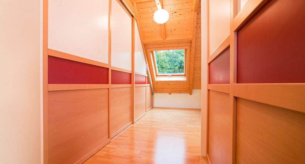 Kleiderschrank unter dem Dach Holz Eichenhaus Gleittüren Schiebetüren Gleittüren, Trennwände und Schrankmöbel von der Schreinerei WERNER AG im Eichenhaus Laufach